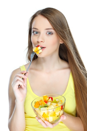 Portrait of a pretty young woman eating fruit salad isolated on  a white backgroundの写真素材