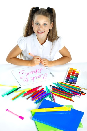 A beautiful girl in a school form drawing a marker, isolated on a white backgroundの写真素材
