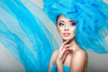 portrait of beautiful girl with a hat from a blue veilの写真素材