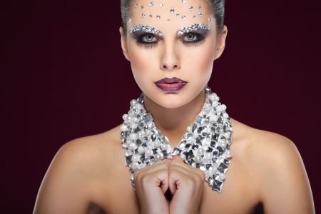 Portrait of sexual beautiful girl with strasses on face, on a violet backgroundの写真素材