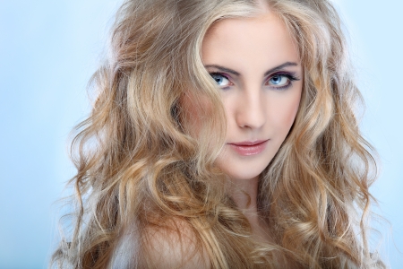 Closeup portrait of sexy whiteheaded young woman with beautiful blue eyes on blue  backgroundの写真素材