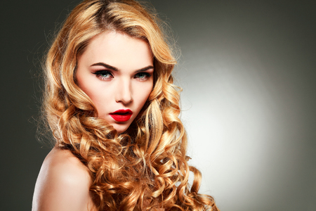 Closeup portrait of sexy  young woman with beautiful blue eyes and red lips on a grey backgroundの写真素材