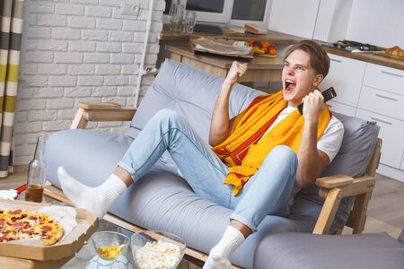 Man watching sport on tv at home alone winの写真素材