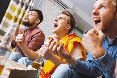 Men watching sport on tv together at home goalの写真素材