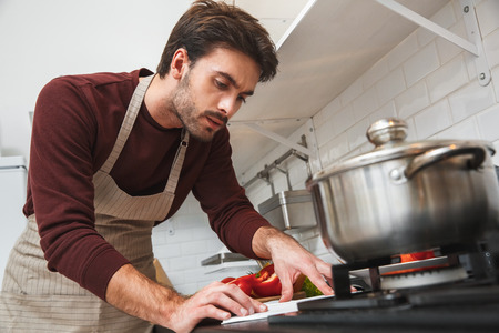 Young man cooking romantic dinner at home reading receipt close-upの写真素材