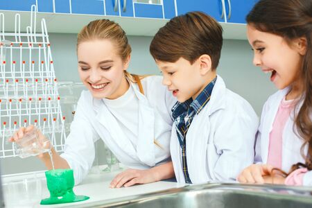 Little kids with teacher in school laboratory acid reactionの写真素材