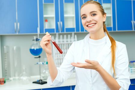 Young chemistry teacher in school laboratory work showing vialの写真素材