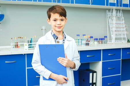 Little child with learning class in school laboratory paper holderの写真素材