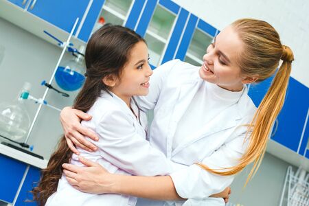 Teacher with little child in school laboratory looking on each otherの写真素材