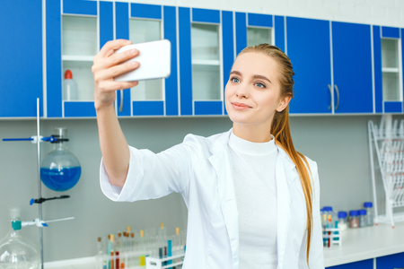 Young chemistry teacher in school laboratory work standing selfieの写真素材