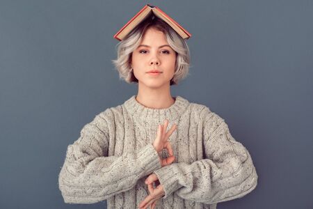 Young woman in a woolen sweater isolated on grey wall winter concept meditatingの写真素材