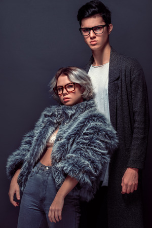 Young man and woman studio shoot isolated on grey wall fashionの写真素材