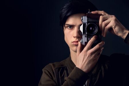 Young man isolated on a grey wall studio concept taking photosの写真素材