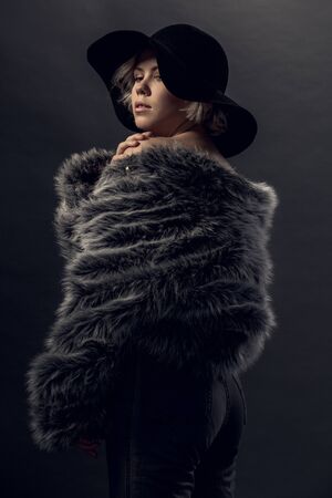 Young woman luxury style isolated on grey wall standingの写真素材