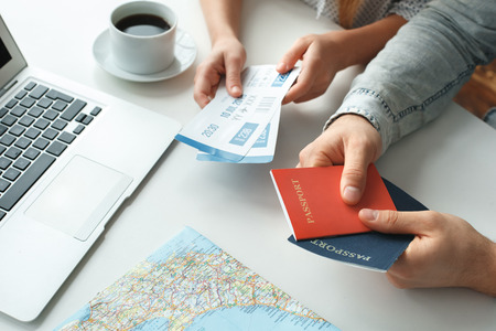 Young couple in a tour agency travelling concept holding passports and ticketsの写真素材