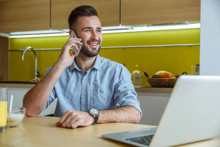 Bachelor man daily routine in the kitchen single lifestyle concept phone callの写真素材