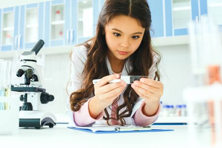 Little child with learning class in school laboratory sample observationの写真素材