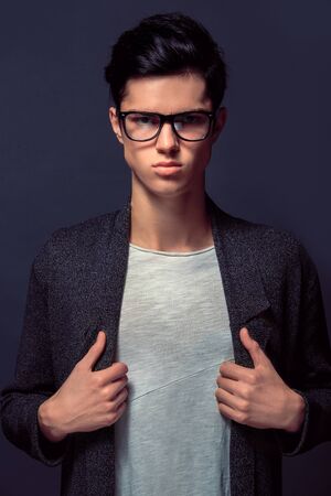 Young man isolated on a grey wall studio concept fashion seriousの写真素材