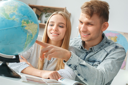 Young couple in a tour agency travelling concept choosing destinationの写真素材