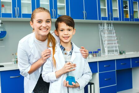 Teacher with little child in school laboratory best studentの写真素材