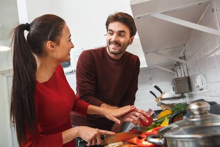 Young couple having romantic evening at home in the kitchen helpの写真素材