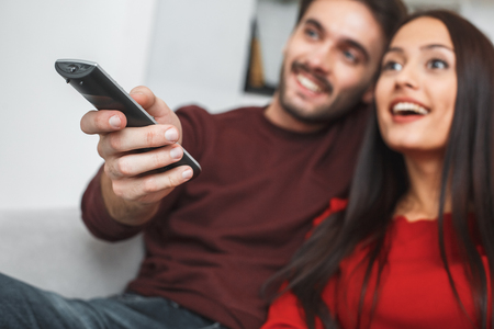Young couple having romantic evening at home watching seriesの写真素材