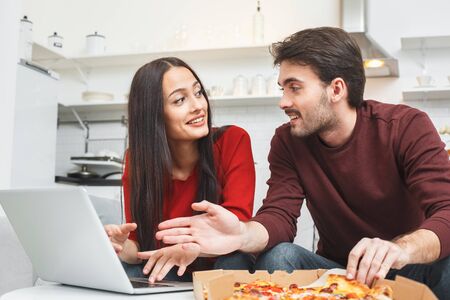 Young couple having romantic evening at home browsing internetの写真素材