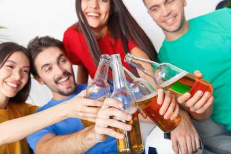 Group of friends sport fans watching match in colorful shirts cheers close-upの写真素材