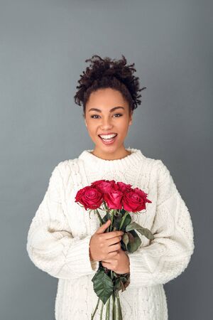 Young african woman isolated on grey wall studio winter concept valentines dayの写真素材