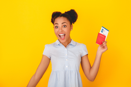 Young african woman isolated on yellow wall studio cute style traveler concept excitedの写真素材