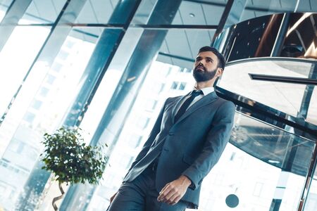 Businessman in a fromal suit in a business center enter the building bottom view