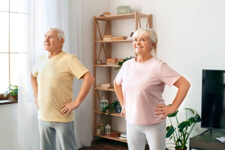 Senior couple exercise together at home health care hands on waist readyの写真素材