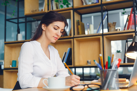 Pregnant business woman working at office motherhood sitting writing reportの写真素材