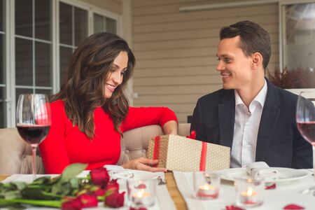 Young couple having romantic dinner in the restaurant looking at presentの写真素材