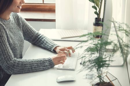Young woman freelancer indoors home office concept casual style working side view close-upの写真素材