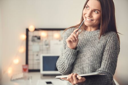 Young woman freelancer indoors home office concept winter atmosphere blurred background planningの写真素材