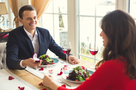 Young couple having romantic dinner in the restaurant proposal ringの写真素材