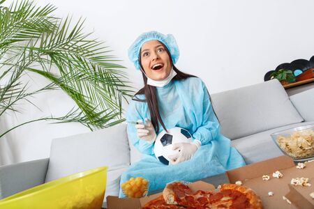 Young woman sport fan watching match supporting favorite teamの写真素材