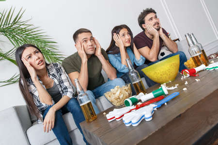 Group of friends sport fans watching soccer match holding headの写真素材