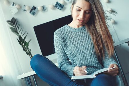 Young woman freelancer indoors home office concept casual style planningの写真素材