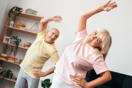 Senior couple exercise together at home health care gymnastic stretchingの写真素材