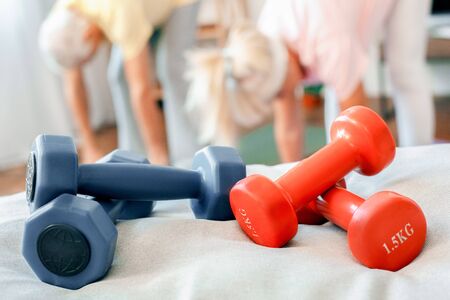 Senior couple stretching together at home health care dumbbells close-up blurred backgroundの写真素材