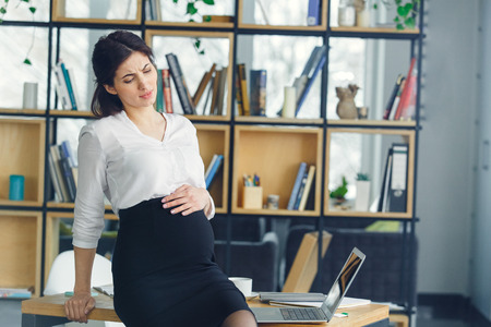 Pregnant business woman working at office motherhood belly painの写真素材