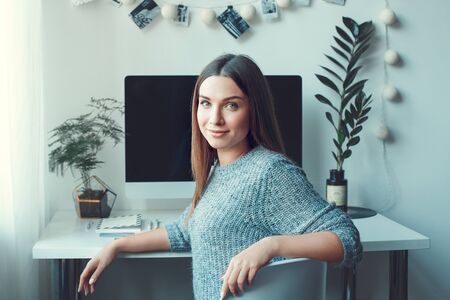 Young woman freelancer indoors home office concept casual style turn backの写真素材