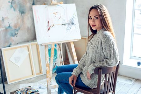Young woman artist painting at home creative ready to createの写真素材