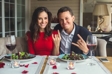 Young couple having romantic dinner in the restaurant sitting together taking photos grimaseの写真素材
