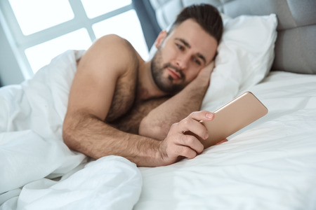 Bachelor man daily routine single lifestyle morning concept checking timeの写真素材