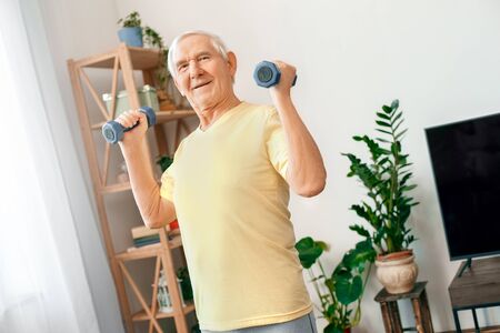 Senior man exercise at home health care with dumbbells strongの写真素材
