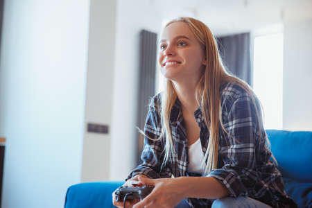 Young woman at home in the living room playing concentratedの写真素材