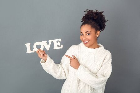 Young african woman isolated on grey wall studio winter concept valentineの写真素材